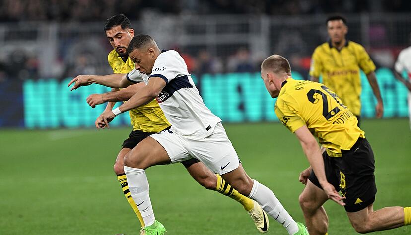 PSG-Superstar Kylian Mbappé (M) im Laufduell mit Emre Can (l) und Julian Ryerson.