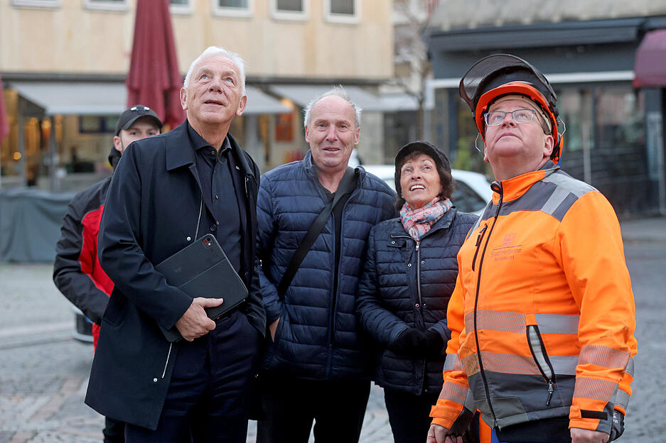 Oberbürgermeister Harry Mergel und das Ehepaar Seiz aus Ilsfeld sind dabei, als der Weihnachtsbaum auf dem Heilbronner Marktplatz aufgestellt wird.