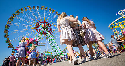 20.04.2019, Baden-Württemberg, Stuttgart: Eine Gruppe junger Frauen läuft am ersten Tag des 81. Stuttgarter Frühlingsfestes über den Cannstatter Wasen. Foto: Christoph Schmidt/dpa +++ dpa-Bildfunk +++