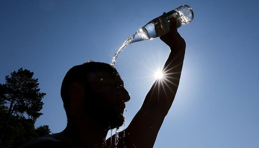 Ein Mann k&uuml;hlt sich bei Hitze ab. (Archivbild)