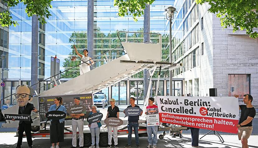 Aktivsten stehen während einer symbolischen Protestaktion am Weltflüchtlingstag zur Unterstützung mehrerer Klagen von Afghanen gegen die Bundesregierung vor dem Auswärtigen Amt. Aktivsten stehen während einer symbolischen Protestaktion am Weltflüchtlingstag zur Unterstützung mehrerer Klagen von Afghanen gegen die Bundesregierung vor dem Auswärtigen Amt.