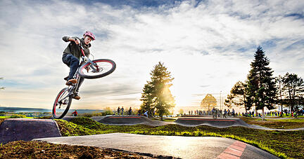 Profis, aber auch Freizeitsportler demonstrieren bei der Eröffnung, was man mit zwei Rädern auf einem Pumptrack machen kann.