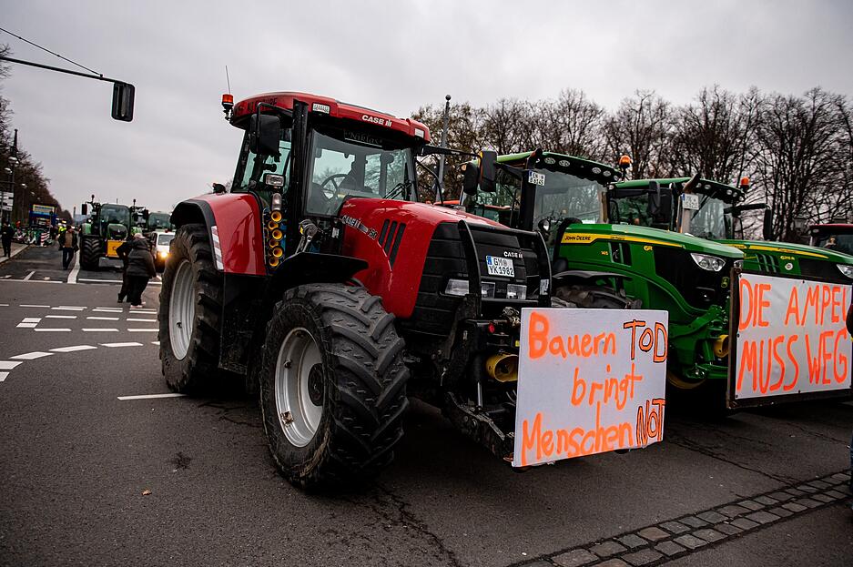 Landwirte nehmen mit ihren Traktoren mit der Aufschriften „Bauern Tod bringt Menschen Not“ und "Die Ampel muss weg" an einer Demonstration des Deutschen Bauernverbandes unter dem Motto «Zu viel ist zu viel! Jetzt ist Schluss!» teil.