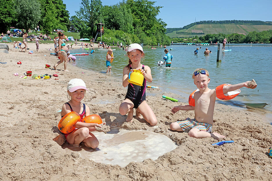 Romy, Ben und Finnja aus Mulfingen spielen im Sand am Breitenauer See.