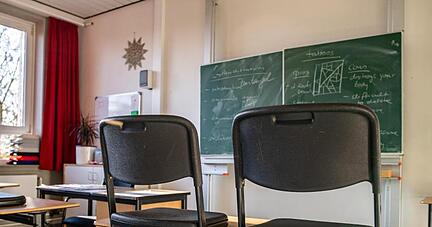 Hochgestellte Stühle in einem leeren Klassenzimmer einer Gesamtschule.