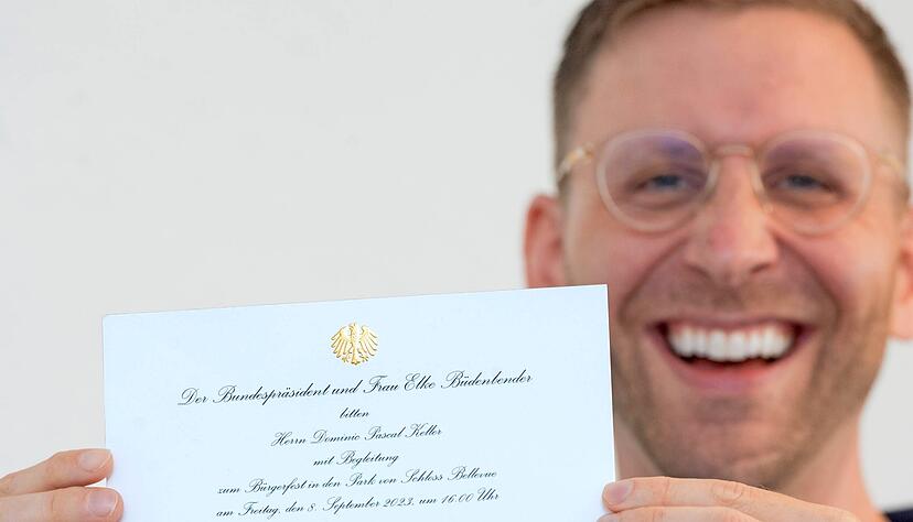 Frauenarzt Dr. Dominic Keller zeigt immer noch grinsend die Einladung aus dem Bundespräsidialamt mit Bundesadler auf dem Briefkopf.