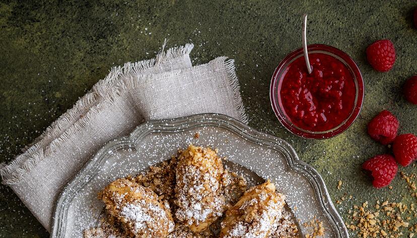 Die mit Zimt und Staubzucker bestäubten und in gerösteten Nüssen gewälzten Topfennockerln genießt man am besten mit einem warmen Beerenpüree. Die mit Zimt und Staubzucker bestäubten und in gerösteten Nüssen gewälzten Topfennockerln genießt man am besten mit einem warmen Beerenpüree.
