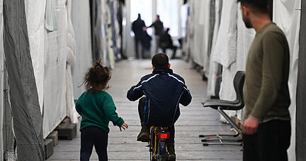 Flüchtlinge sind in einem der Zelte einer provisorischen Flüchtlingsunterkunft unterwegs. Am 30. März findet ein Kommunalgipfel der Unionsfraktion zur Asyl- und Flüchtlingspolitik statt. Thema sind die Probleme bei der Unterbringung von Flüchtlingen. +++ dpa-Bildfunk +++