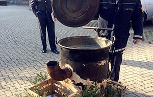 Polizisten begutachten den Kessel, in dem sich am Wochenende eine junge Frau mit heißem Wasser an den Beinen verbrüht hatte. Foto: dpa Polizisten begutachten den Kessel, in dem sich am Wochenende eine junge Frau mit heißem Wasser an den Beinen verbrüht hatte. Foto: dpa