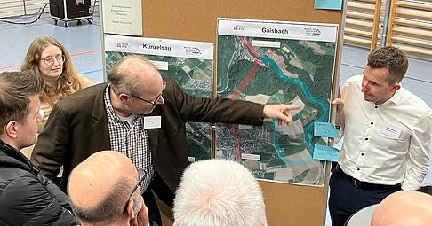 Rainer Flotho vom Planungsb&uuml;ro TTK erkl&auml;rt Besuchern die Trassenvarianten zwischen K&uuml;nzelsau und Gaisbach. Rechts B&uuml;rgermeister Stefan Neumann.