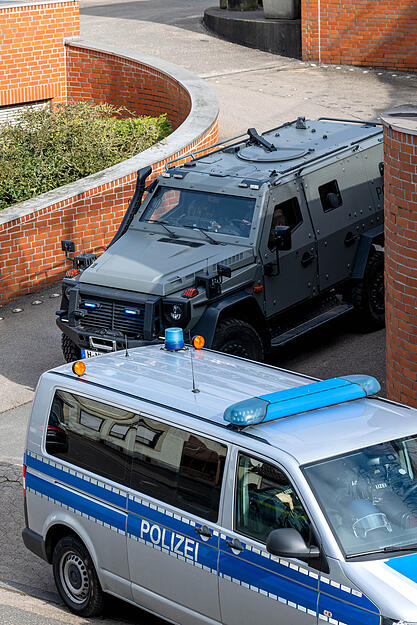 Ein gepanzertes Fahrzeug der Polizei verl&auml;sst in einer Kolonne mit weiteren Polizeifahrzeugen das Amtsgericht.