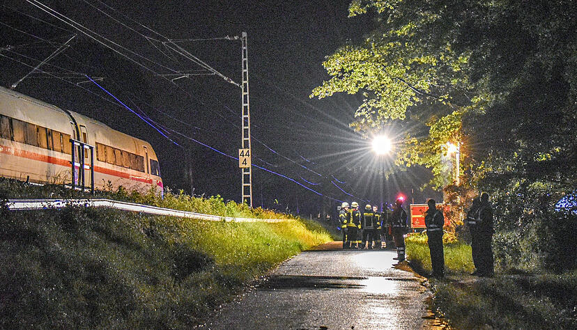 Einsatzkräfte stehen am Abend an der Bahnlinie bei Schwäbisch Gmünd. Zwei Waggons eines ICE mit 185 Passagieren an Bord waren nach einem Erdrutsch entgleist. Einsatzkräfte stehen am Abend an der Bahnlinie bei Schwäbisch Gmünd. Zwei Waggons eines ICE mit 185 Passagieren an Bord waren nach einem Erdrutsch entgleist.