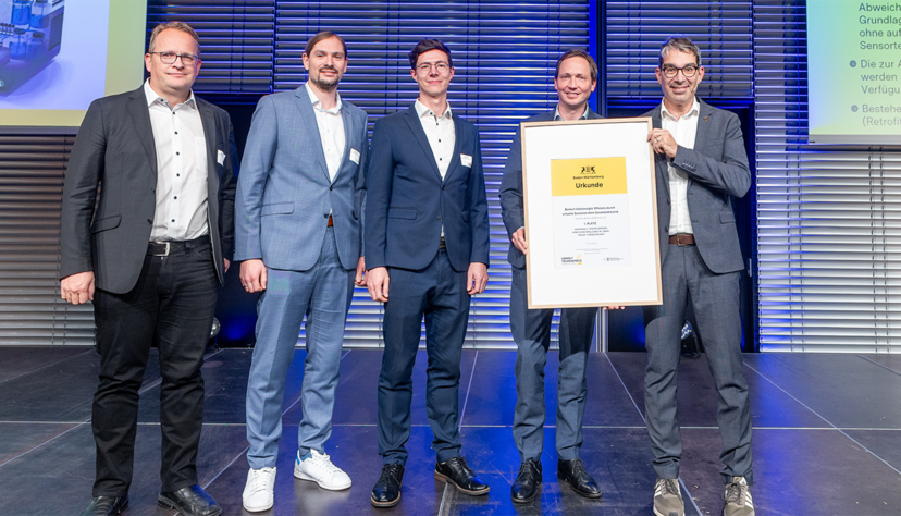 Michael Hartte, Fabian Mittnacht, Josua Printz und Technikvorstand Stefan Müller von Bürkert bei der Urkundenübergabe durch Staatssekretär Andre Baumann.