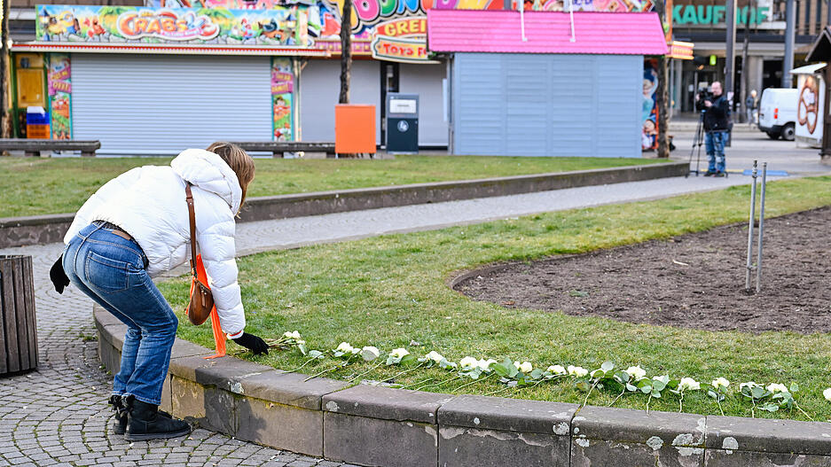 Eine Frau legt in der Nähe des Mannheimer Paradeplatzes weiße Rosen auf eine Grünfläche. Eine Frau legt in der Nähe des Mannheimer Paradeplatzes weiße Rosen auf eine Grünfläche.