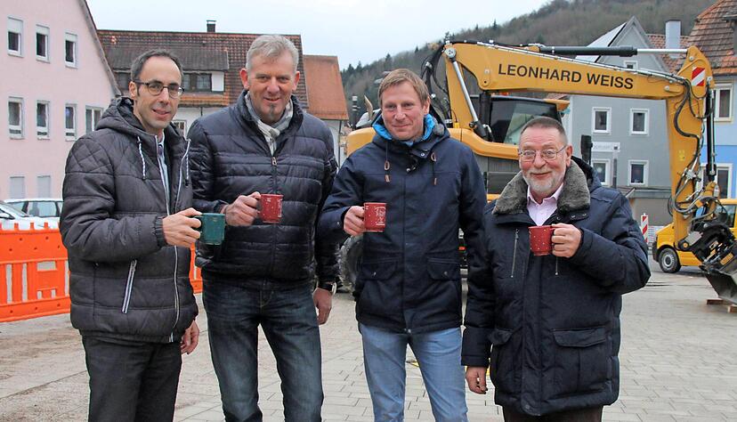 Tassen hoch auf dem Marktplatz (v. l.): Bürgermeister Frank Harsch, Weiss-Projektleiter Martin Ziegler, Planer Marcus Eissing und Gemeinderat Walter Falk. Foto: Färber