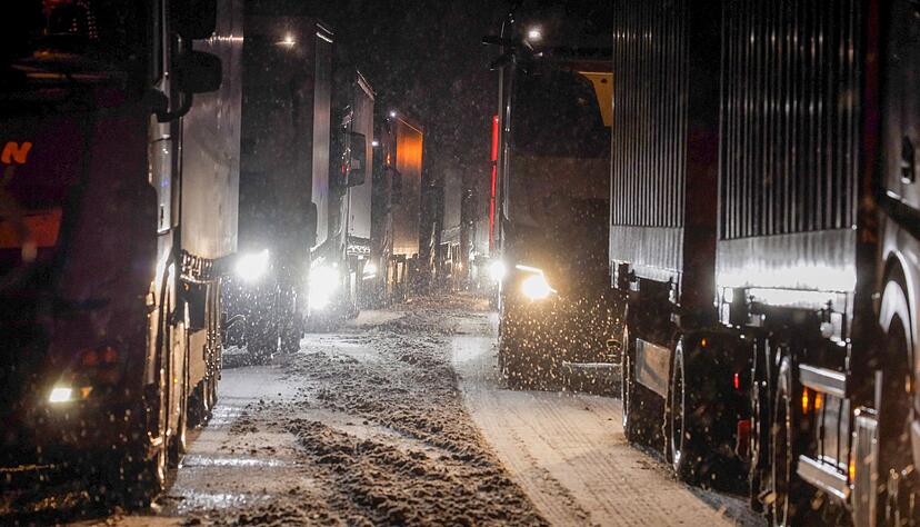 Lkw sind auf der schneebedeckten Fahrbahn stecken geblieben.