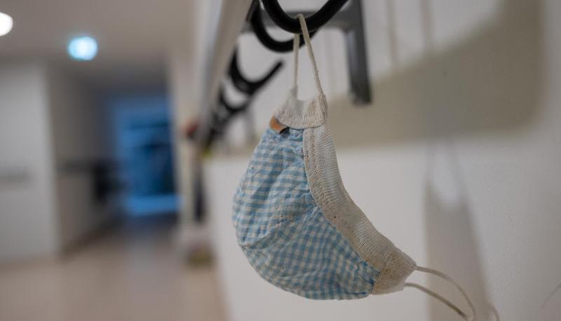 Eine Maske h&auml;ngt im Korridor einer Schule.