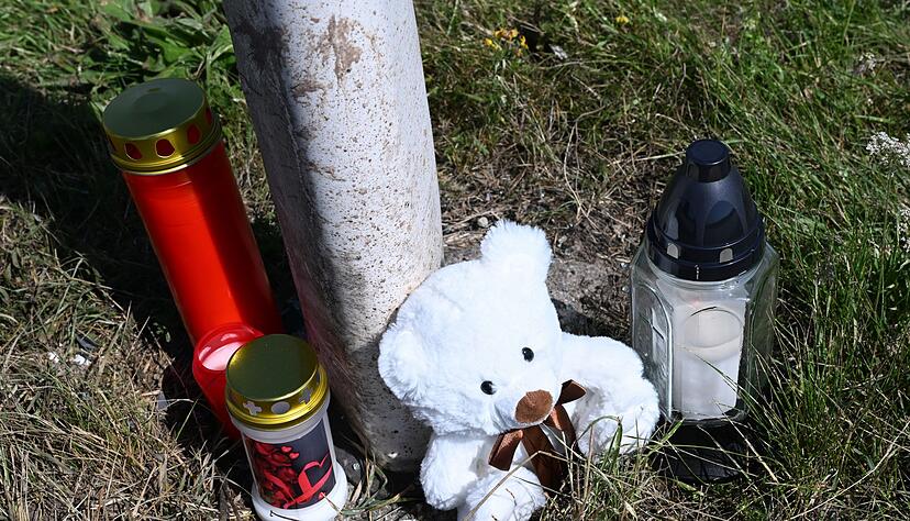 Menschen haben Kerzen und einen Teddybären an der Unfallstelle abgestellt. Menschen haben Kerzen und einen Teddybären an der Unfallstelle abgestellt.