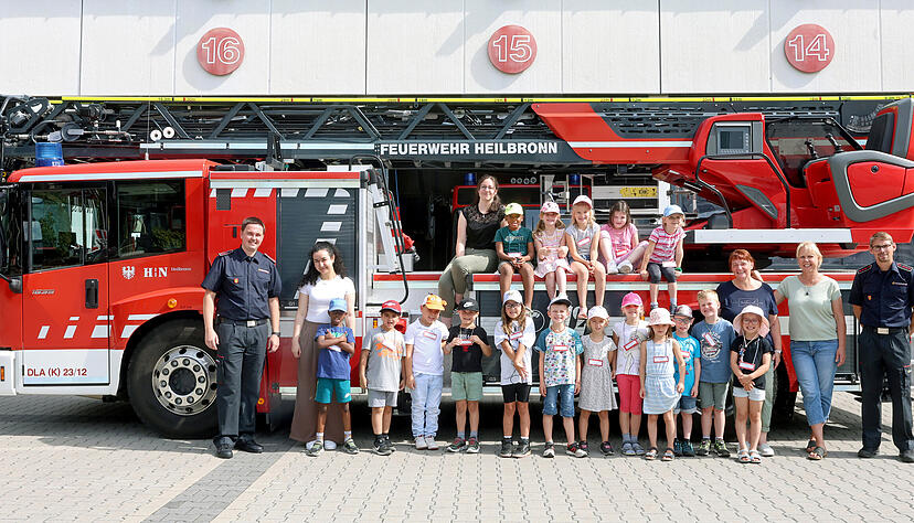 Tim Rocksien (li.) und Michael Steudle (re.) von der Feuerwehr mit Erzieherinnen und Kindern aus Gundelsheim.