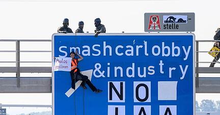 Ein Aktivist bei einer Banneraktion an einer Schilderbr&uuml;cke &uuml;ber der Autobahn A9 bei F&uuml;rholzen in Fahrtrichtung M&uuml;nchen.