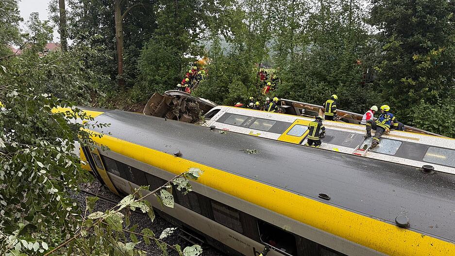 Rettungskräfte suchen in einem entgleisten Zug nach Fahrgästen.