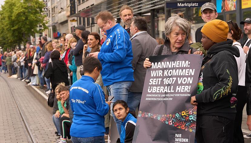 Bürgerinnen und Bürger demonstrieren in Mannheim mit einer Menschenkette gegen Gewalt, Hass und Hetze.