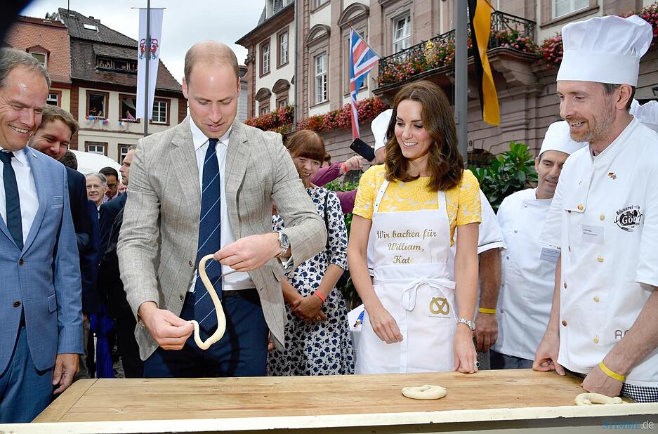 Auf dem Marktplatz in Heidelberg werden Brezeln geformt, links steht Heidelbergs Oberbürgermeister Eckart Würzner, rechts beobachtet Bäcker Andreas Göbes die Szene. Foto: dpa
