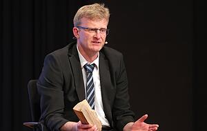 Bildersprache: Alle Kandidaten sind aufgefordert, einen Gegenstand ihrer Wahl mit auf die Bühne zu bringen: Andreas Insam hat sich für den Holzscheit entschieden.