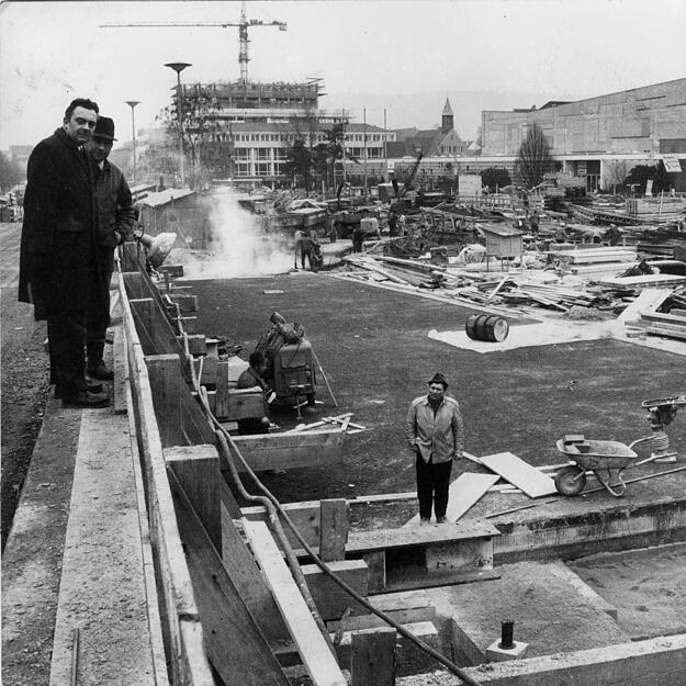 Überall wird an der Heilbronner Allee gebaut. Die Aufnahme von 1971 zeigt den ersten Fahrbahnbelag über der neuen Unterführung und den Abriss der Behelfsbusbrücke über das Alleekreuz. Im Hintergrund wächst das Shoppinghaus in die Höhe.