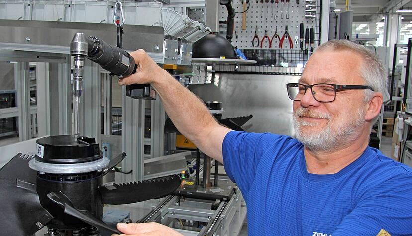 Die gro&szlig;e Nachfrage befl&uuml;gelt die Herstellung von Ventilatoren f&uuml;r W&auml;rmepumpen: Markus Weiser montiert einen Axialventilator mit EC-Motor im Werk Kupferzell.