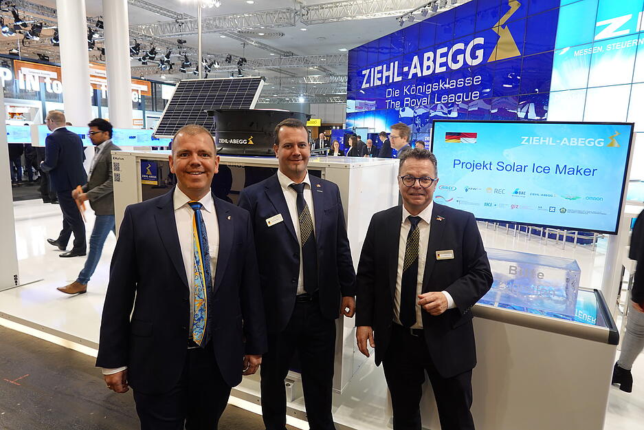 Ziehl-Abegg-Sprecher Rainer Grill (von rechts), Marketingleiter Andreas Bauer und Gesellschafter Dennis Ziehl vor dem Solar Ice Maker, der D&ouml;rfern in Indonesien die M&ouml;glichkeit geben soll, autark den gefangenen Fisch zu k&uuml;hlen.