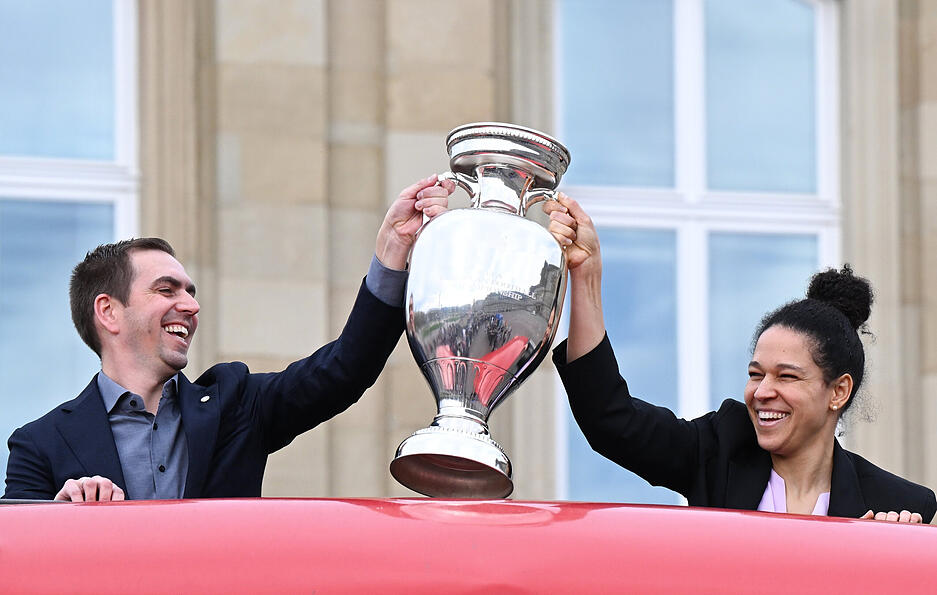 Philipp Lahm (l.), Turnierdirektor der Fußball Europameisterschaft, hält zusammen mit der früheren Fußball Nationalspielerin Celia Sasic den Pokal für die Fußball Europameisterschaft.