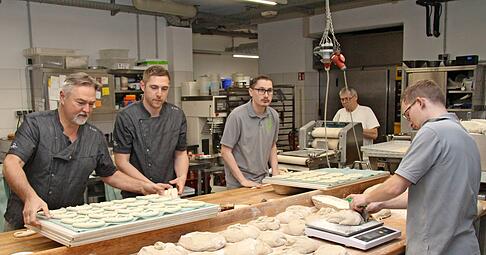 Brezelrollen: (v. li.) Stefan Kolb, Sohn Marcel, Geselle Pascal, Bruder Lothar (71). Vorne: Phillip beim Brotteigwiegen.