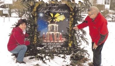 Ruth Heidenfelder und Wolfgang Sch&auml;dler schm&uuml;cken am Ortseingang das Werbeschild f&uuml;r die Dorfweihnacht.Foto: Cordula D&uuml;rr