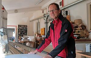 Michael Ehrler, der die Schreinerei in der achten Generation führt, an einer Kantenleimmaschine in der Werkstatt in Jagstberg. An dem etwa 300 .000 Euro teuren Gerät werden zum Beispiel Kunststoffbänder an die Seiten von Regalbrettern geleimt.