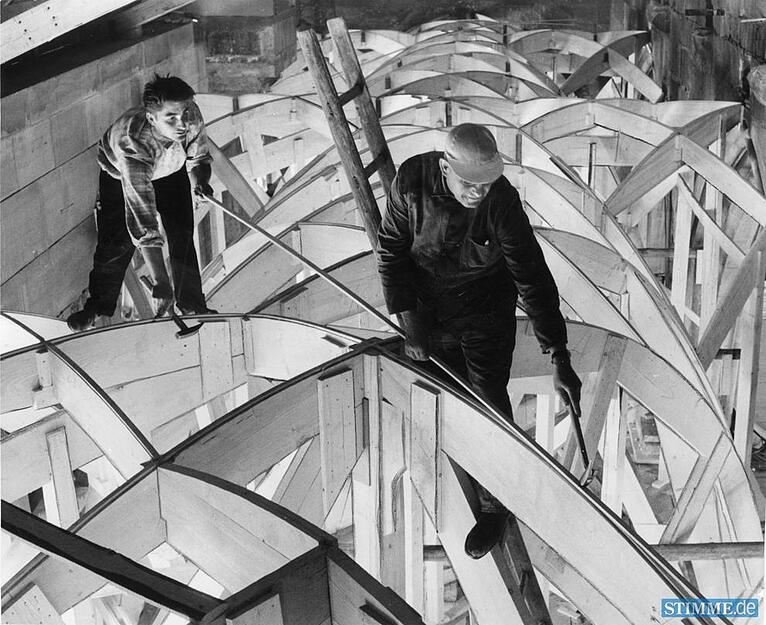 Im südlichen Seitenchor der Kilianskirche legt Zimmermeister Ernst Häfele im Mai 1960 letzte Hand an die komplizierte Holzkonstruktion. Deutlich zeichnet sich das Gewölbenetz ab. Über den Holzbögen werden die steinernen Rippen zu dem Netz zusammengefügt.