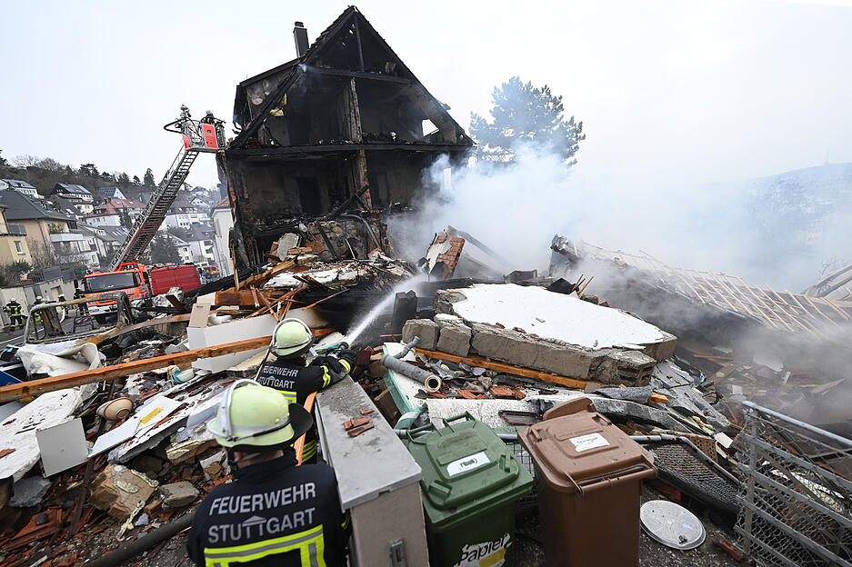 An der Unglücksstelle in Stuttgart West löschen Feuerwehrleute den Brand und suchen nach einer vermissten 85-jährigen Bewohnerin. Nach einer Explosion in der Nacht in einem Wohnhaus in Stuttgart sind Teile des Gebäudes eingestürzt.