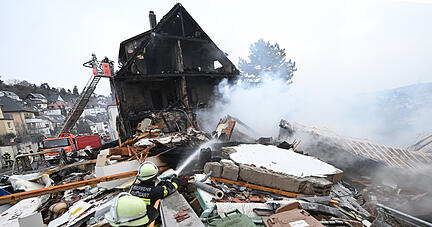 An der Unglücksstelle in Stuttgart West löschen Feuerwehrleute den Brand und suchen nach einer vermissten 85-jährigen Bewohnerin. Nach einer Explosion in der Nacht in einem Wohnhaus in Stuttgart sind Teile des Gebäudes eingestürzt.