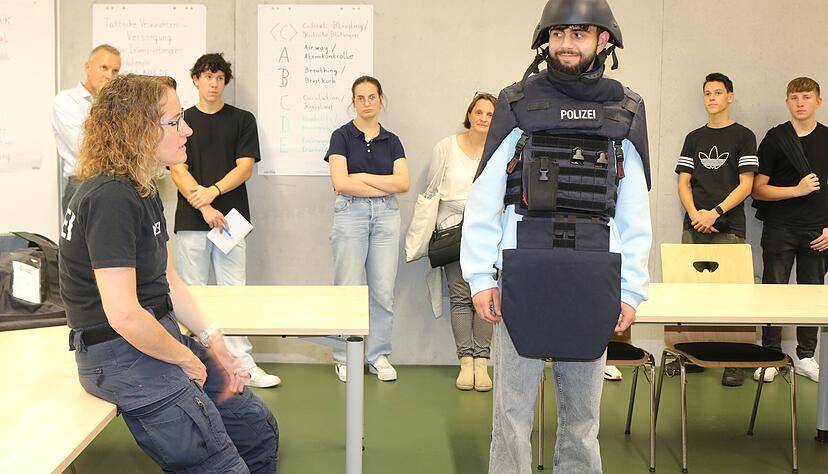 Ömer Faruk Ucar hat sich von Polizeibeamtin Miriam Bauer schon mal die Polizeiausrüstung anlegen lassen. Fotos: Ute Plückthun Ömer Faruk Ucar hat sich von Polizeibeamtin Miriam Bauer schon mal die Polizeiausrüstung anlegen lassen. Fotos: Ute Plückthun