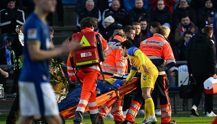Paderborns Spieler Calvin Brackelmann wird nach einer Verletzung von Sanit&auml;tern auf einer Trage vom Spielfeld gebracht.