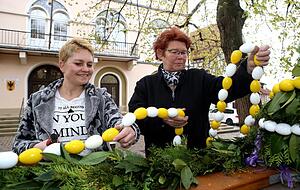 W&auml;hrenddessen bringen Katharina Staudt (links) und Gisela Sch&auml;fer eine Kette aus wei&szlig;en und gelben Plastikeiern am Brunnenrand an. Fotos: Ralf Seidel