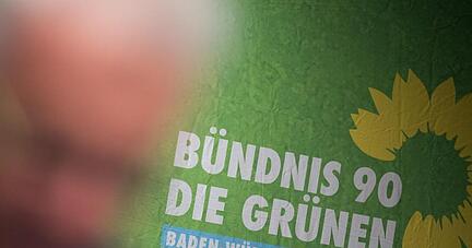 Der Ministerpr&auml;sident von Baden-W&uuml;rttemberg Winfried Kretschmann spricht vor einem Logo seiner Partei.