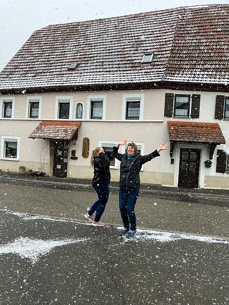 Zwei Mitarbeiterinnen einer Mulfinger Metzgerei machen einen Freudentanz wegen der Schneeflocken.