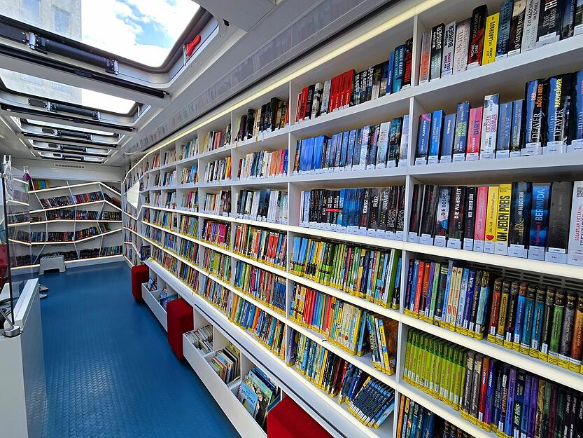 Ein Blick ins Innere der Fahrbücherei zeigt Regale voller Bücher, Hörbücher und Lernmedien.