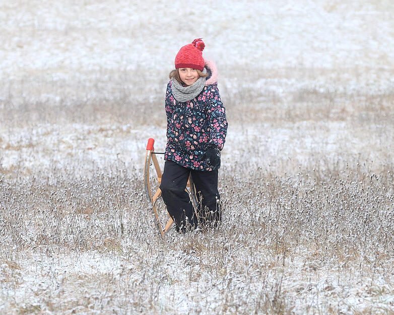 Kinder und Erwachsene genie&szlig;en Rodelspa&szlig; in der winterlichen Landschaft.