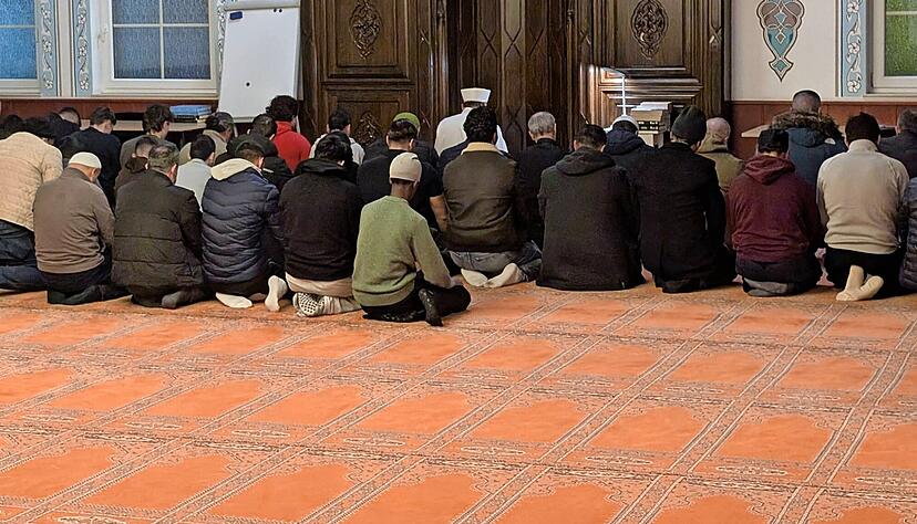 In der Gebetsnische, die nach Osten ausgerichtet ist, sitzt der Imam beim Abendgebet vor den Gl&auml;ubigen.