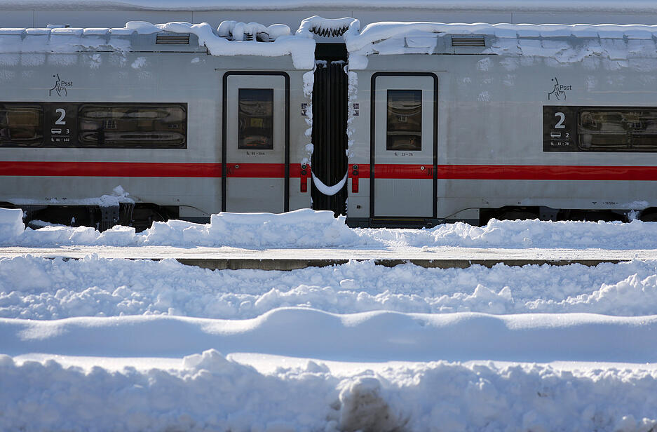 Ein mit Schnee bedeckter ICE steht im Hauptbahnhof. Nach dem starken Wintereinbruch in Bayern gab es bei der Bahn auch am Sonntagmorgen noch massive Einschränkungen.