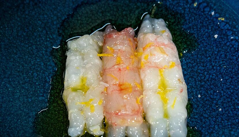 Simpel, aber effektvoll: Scampi-Filets werden in d&uuml;nne Scheiben geschnitten und mit einem Spritzer Zitrone, etwas Meersalz, Zitronenabrieb und Oliven&ouml;l abgerundet.