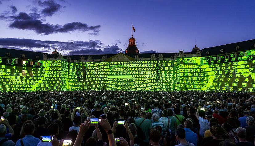 "Nummern": Kraftwerk tauchen für ihr einziges Deutschland-Konzert in diesem Jahr die gesamte Fassade des Karlsruher Schlosses in grüne Ziffern. 16 000 Zuschauer erleben die Multimedia-Show.
Fotos: dpa "Nummern": Kraftwerk tauchen für ihr einziges Deutschland-Konzert in diesem Jahr die gesamte Fassade des Karlsruher Schlosses in grüne Ziffern. 16 000 Zuschauer erleben die Multimedia-Show.
Fotos: dpa