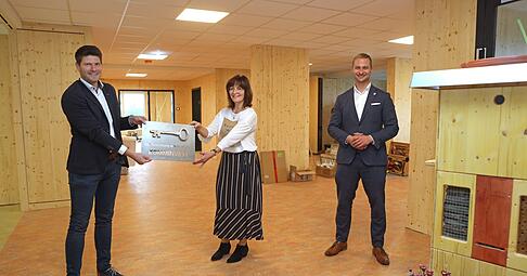 Tobias Kn&uuml;lle (von links), Christina Veyel und Thomas Einfalt freuen sich &uuml;ber die neue Kita. Kn&uuml;lle &uuml;berreichte neben dem Schl&uuml;ssel auch ein Insektenhotel.